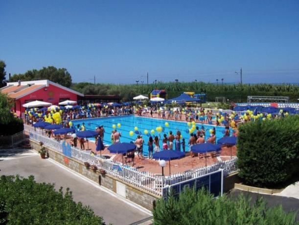 Piscina all'aperto attrezzata con sdraio e ombrelloni 